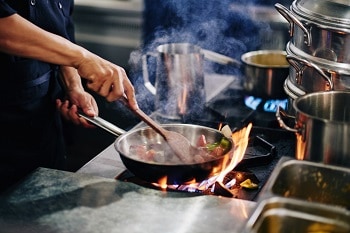 Chef cooking in all clad Copper Core fry pan